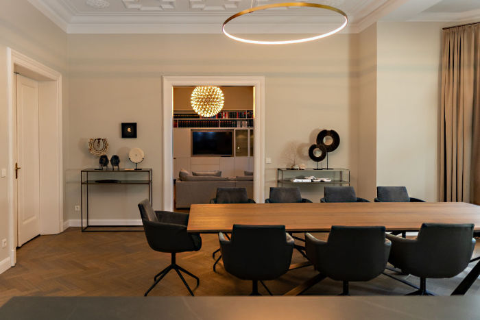 In diesem großen Altbau-Esszimmer wurde ein maßangefertigter Eichentisch, der Platz für 10 Personen bietet,  in einer Manufaktur angefertigt. Hochwertige Drehstühle mit speziell pflegeleichtem Samt ergänzen das Ensemble. Die beiden maßangefertigten Boards beherbergen originale Artefakte. Die gesamte Beleuchtung in diesem Innenarchitektur-Projekt sind dimmbar. – Interior made by Katja A. Marocke